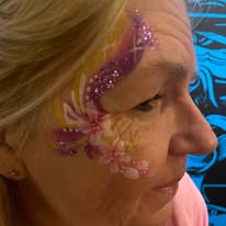 Floral face paint design near the eye